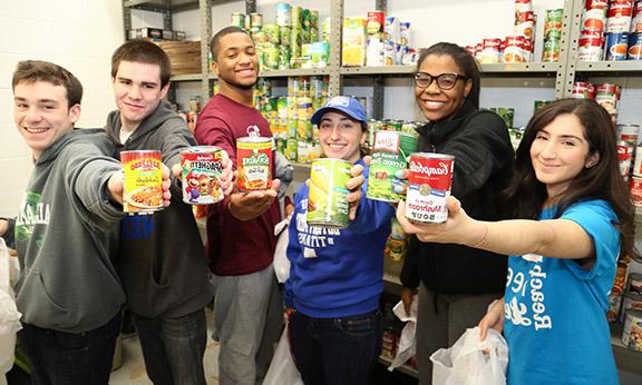 Group of students holding cans of food